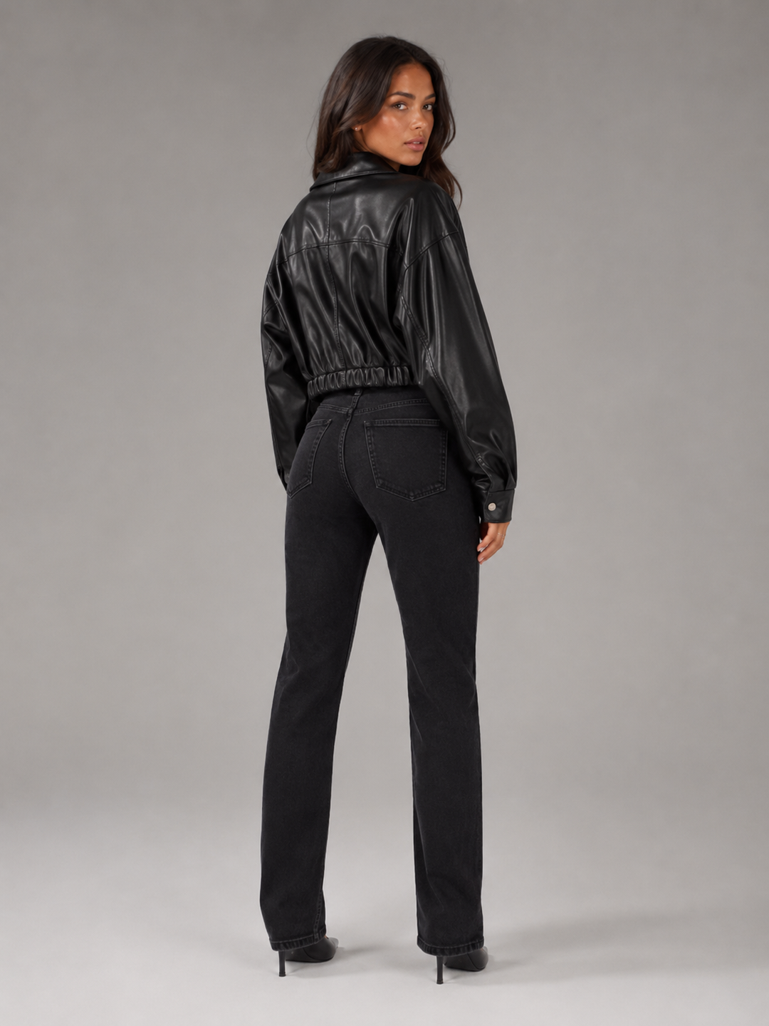 Woman wearing a cropped faux leather biker jacket with notch lapels