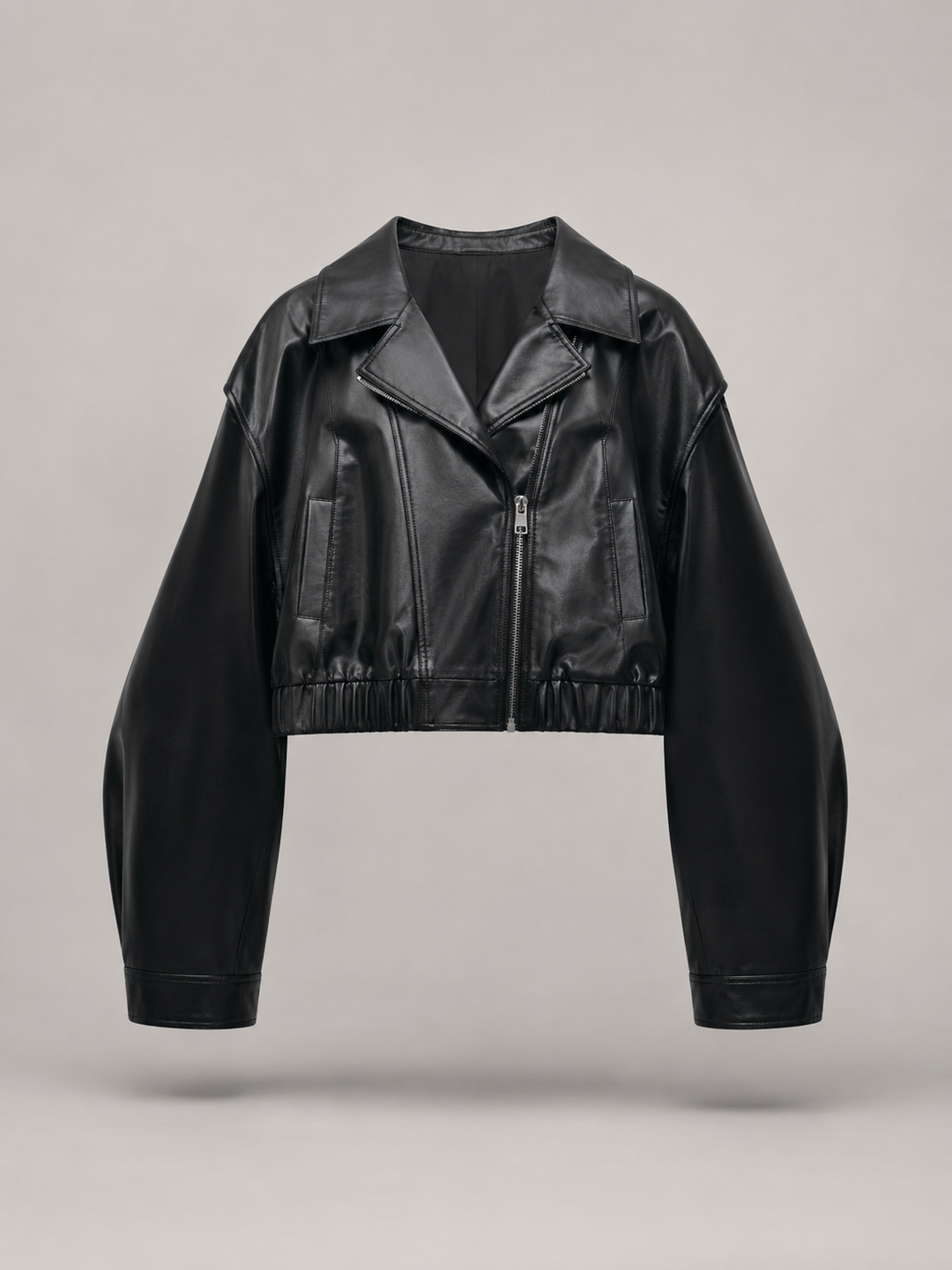 Woman wearing a cropped faux leather biker jacket with notch lapels