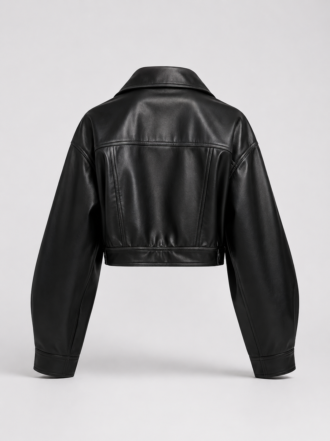 Woman wearing a cropped faux leather biker jacket with notch lapels