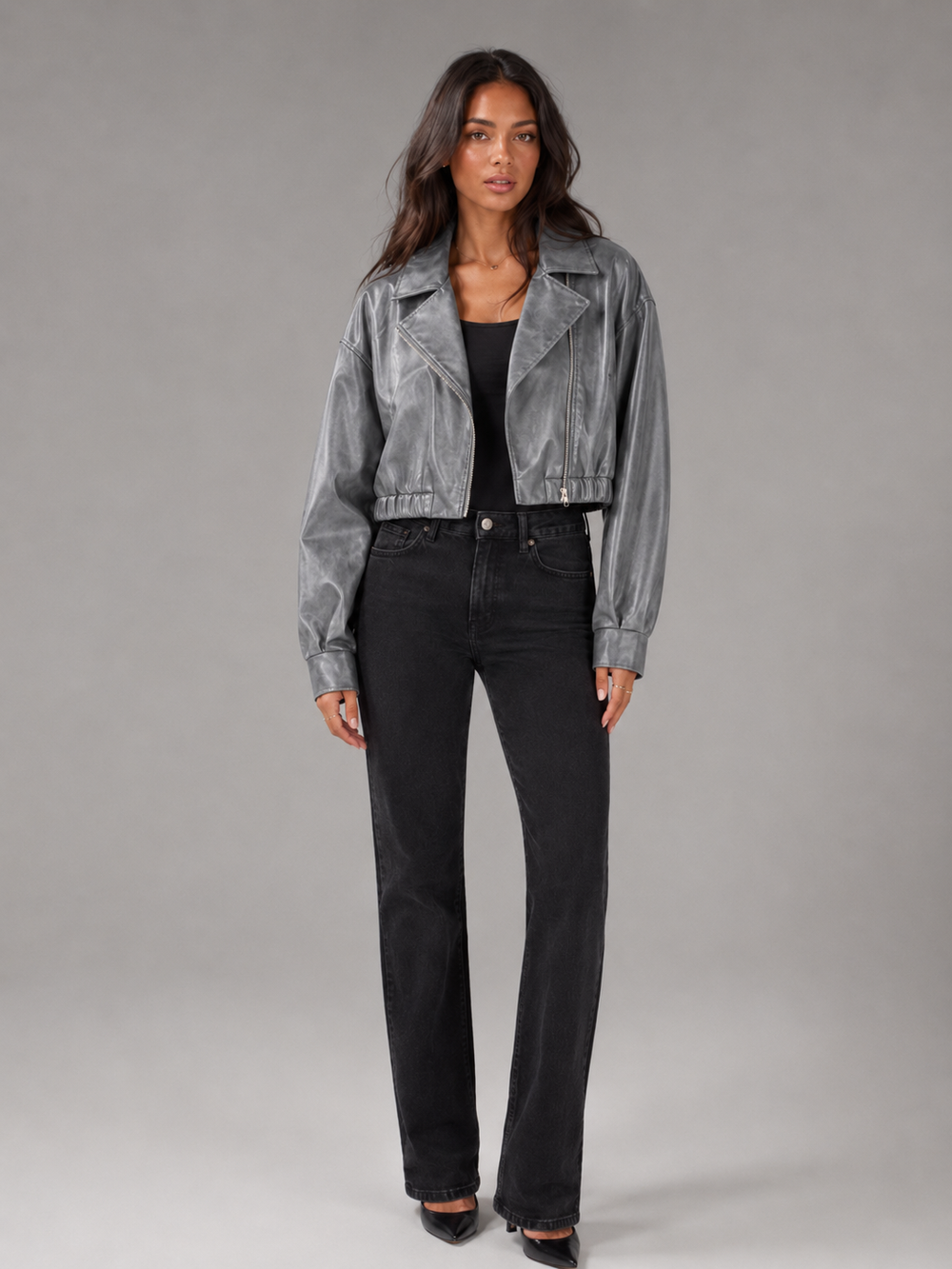 Woman wearing a cropped faux leather biker jacket with notch lapels