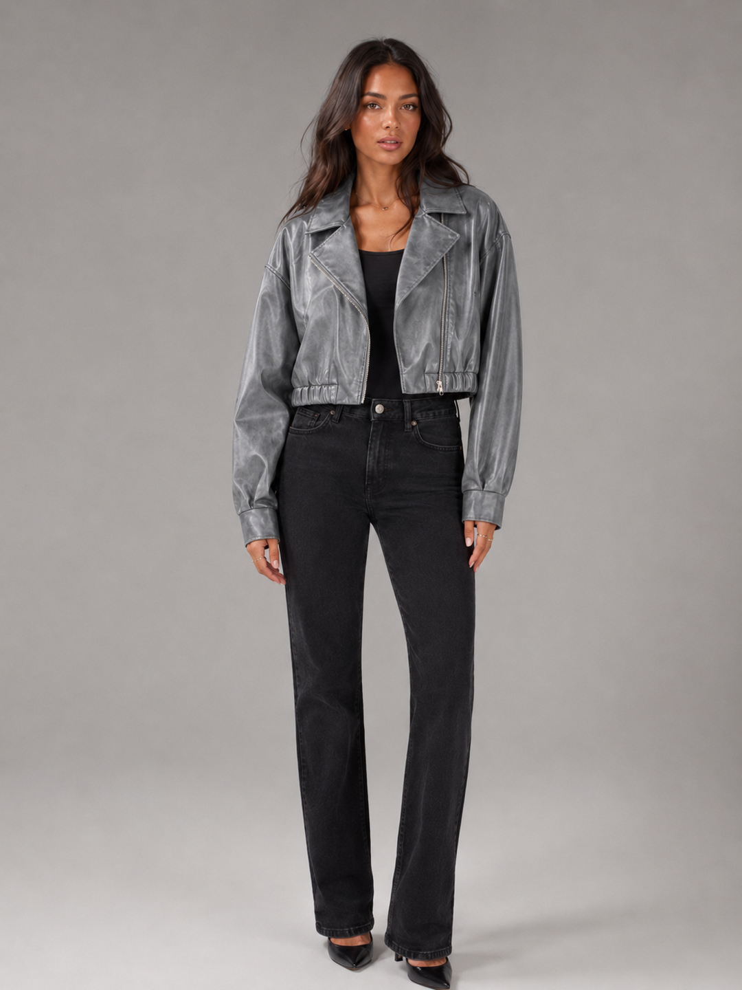 Woman wearing a cropped faux leather biker jacket with notch lapels