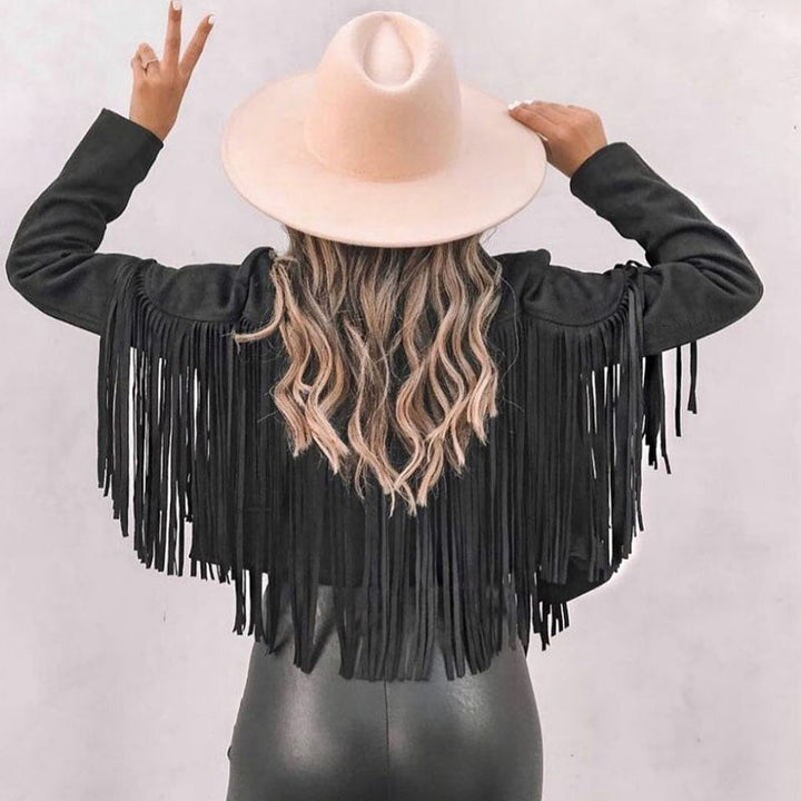 Woman wearing a fringe faux leather biker jacket with a cropped western cut