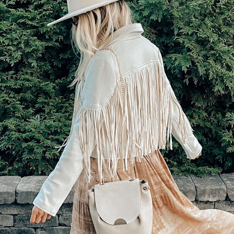 Woman wearing a fringe faux leather biker jacket with a cropped western cut