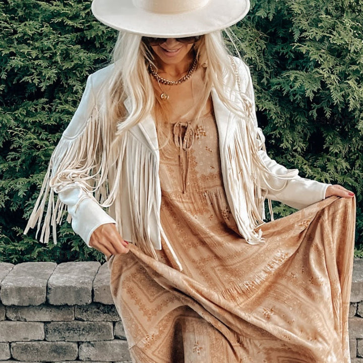 Woman wearing a fringe faux leather biker jacket with a cropped western cut