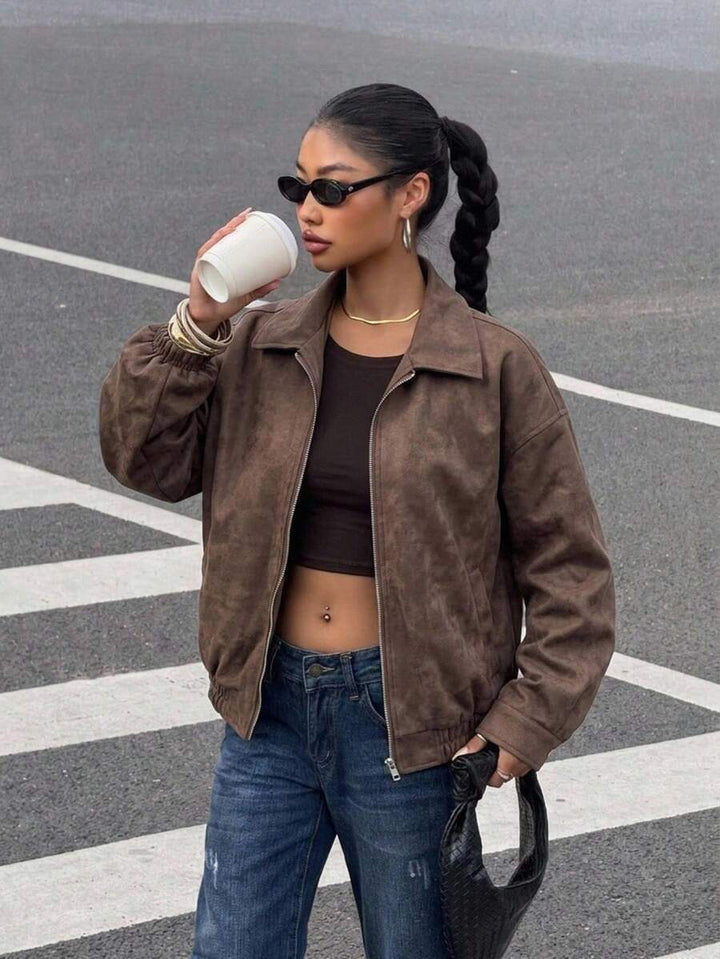 Woman wearing a slouchy oversized faux leather jacket with a dropped shoulder
