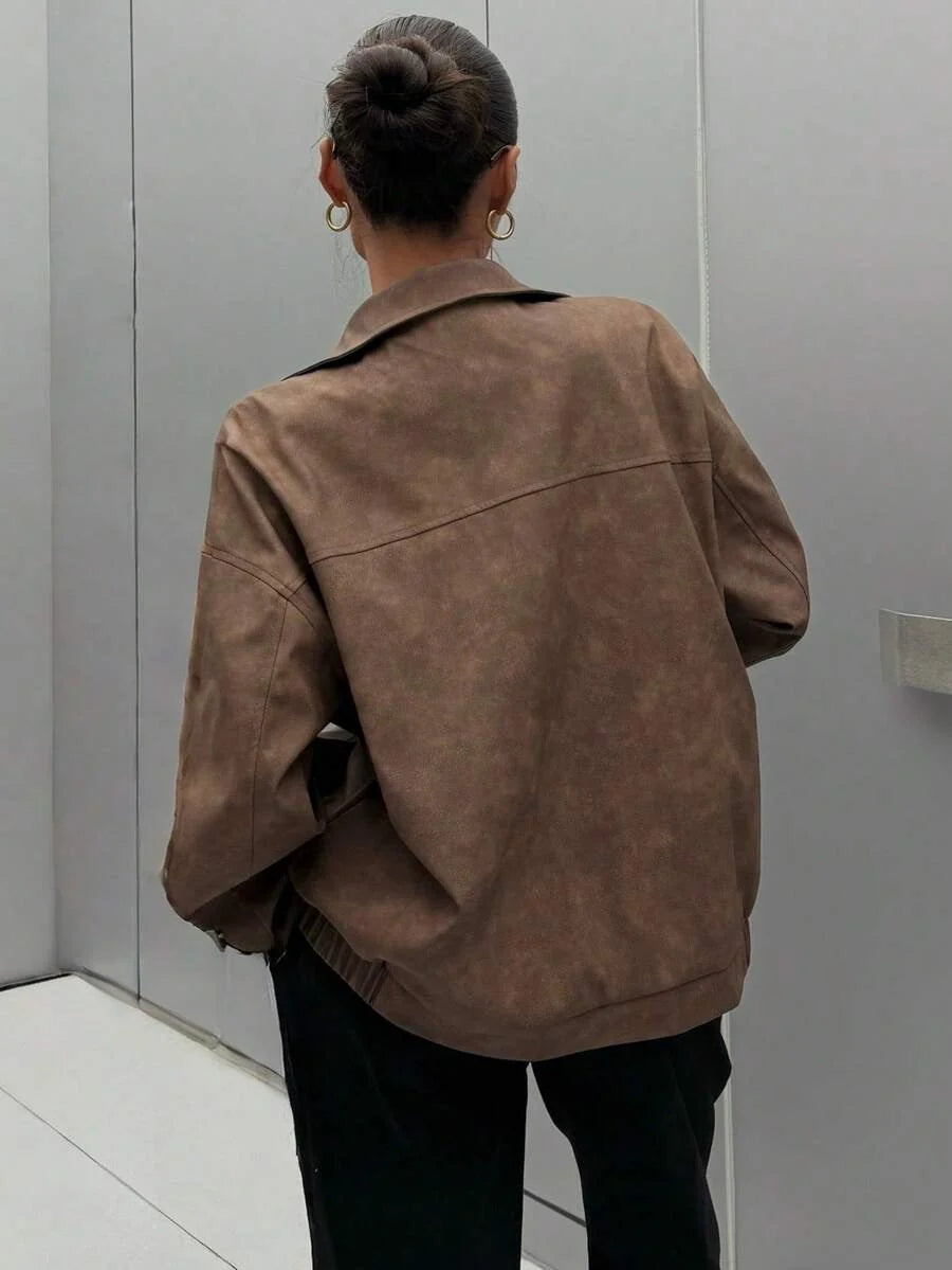 Woman wearing a slouchy oversized faux leather jacket with a dropped shoulder