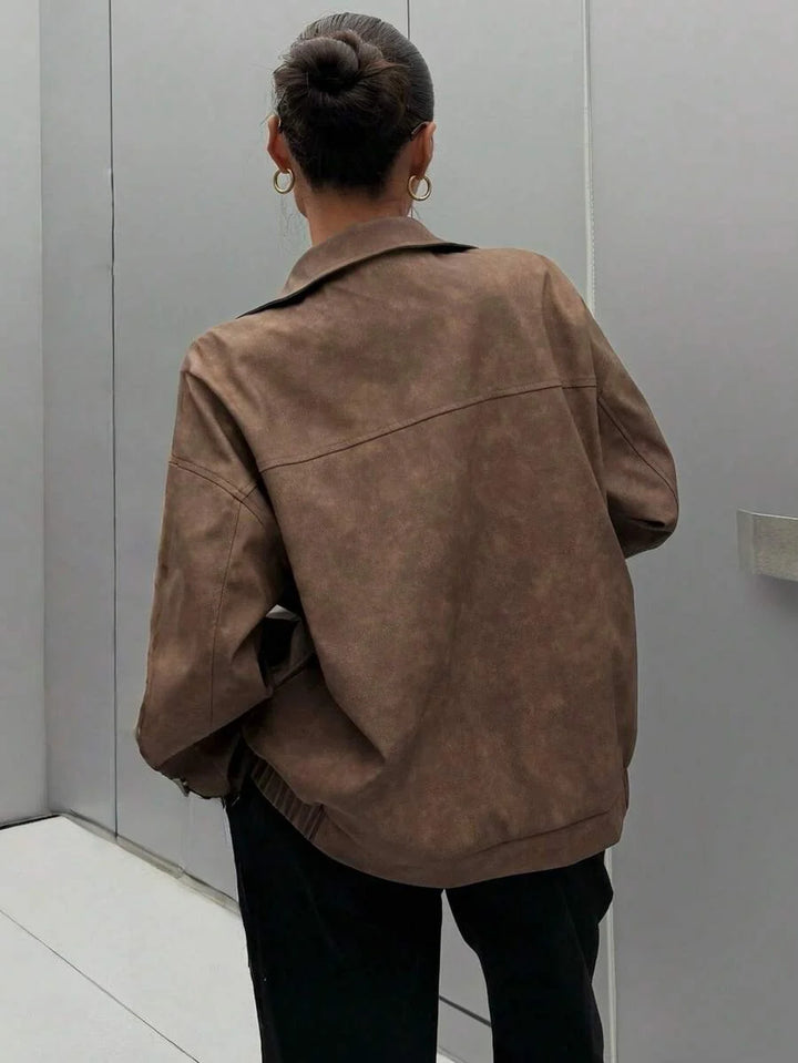 Woman wearing a slouchy oversized faux leather jacket with a dropped shoulder