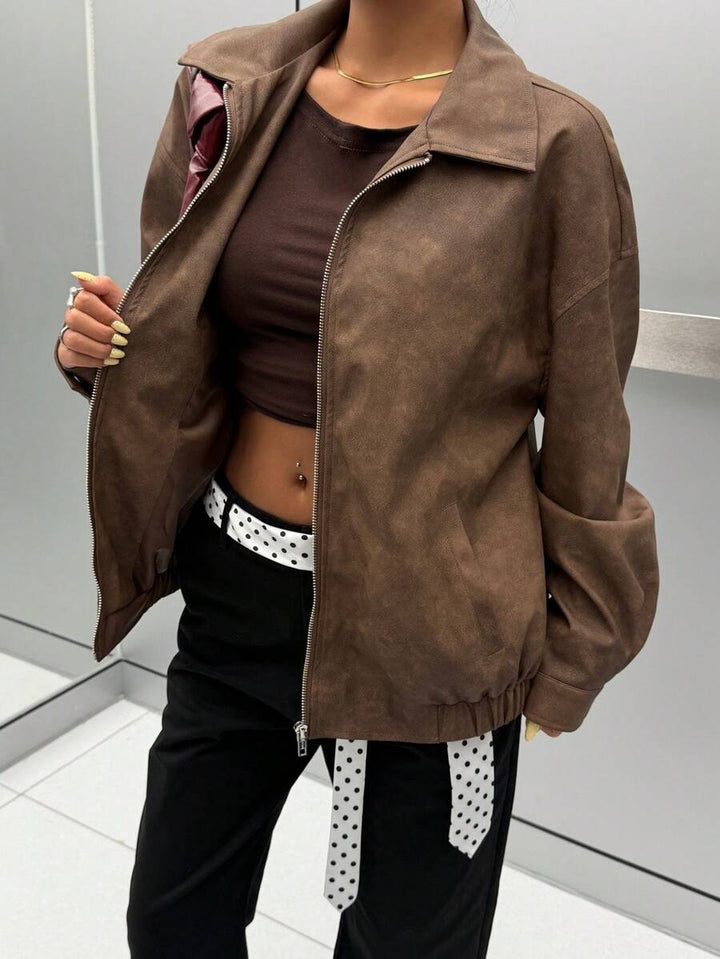 Woman wearing a slouchy oversized faux leather jacket with a dropped shoulder
