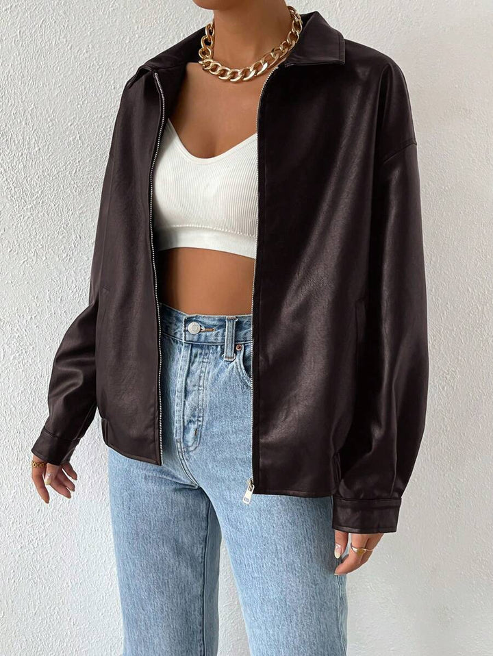 Woman wearing a slouchy oversized faux leather jacket with a dropped shoulder