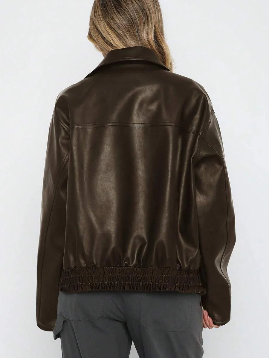 Woman wearing an oversized faux leather jacket with a wide collar and gathered hem
