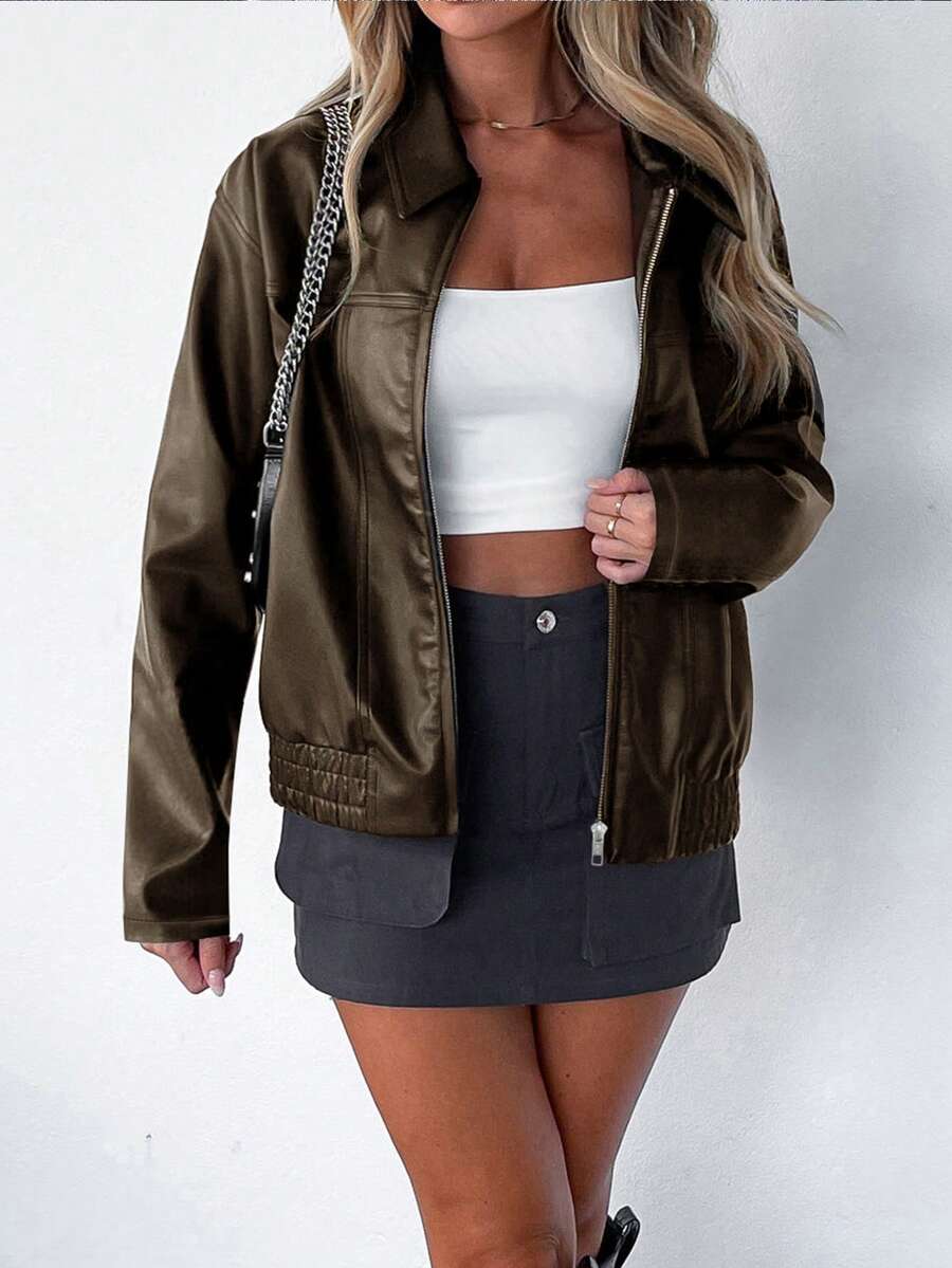 Woman wearing an oversized faux leather jacket with a wide collar and gathered hem