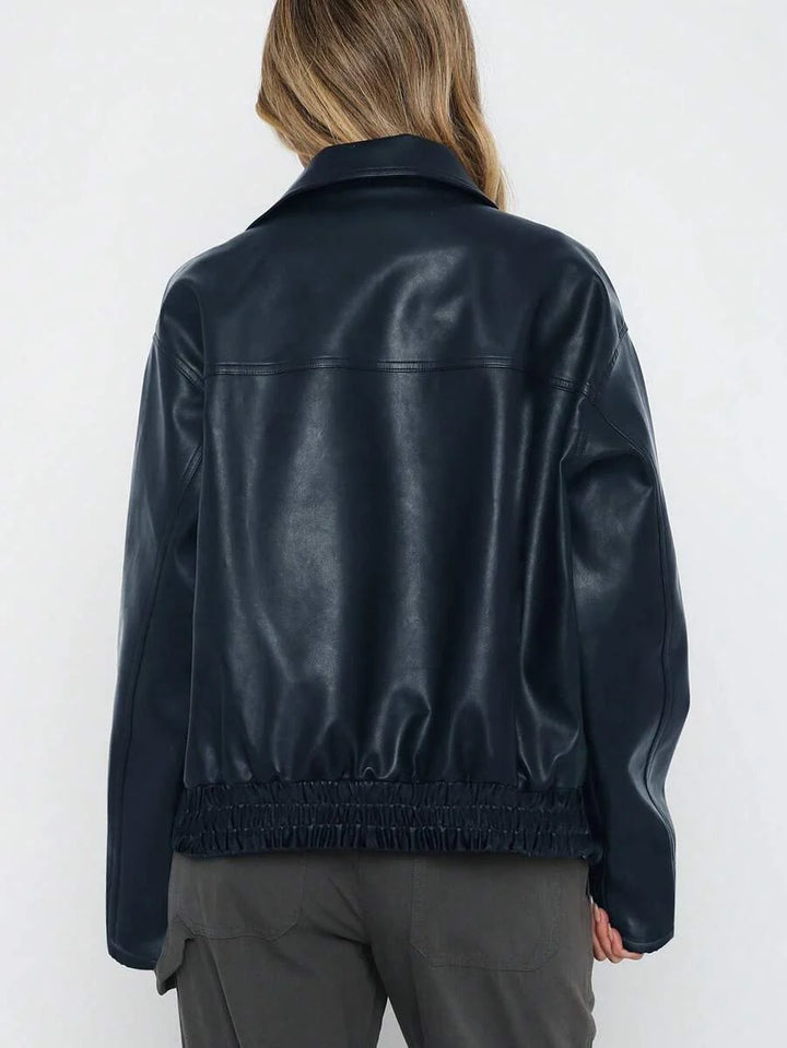 Woman wearing an oversized faux leather jacket with a wide collar and gathered hem