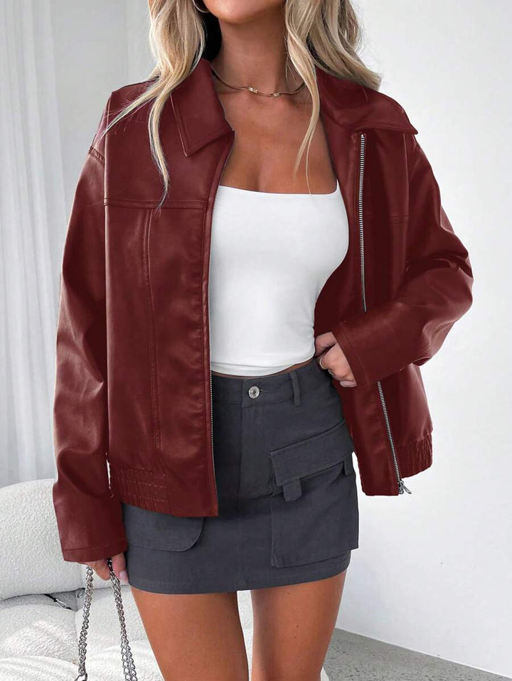 Woman wearing an oversized faux leather jacket with a wide collar and gathered hem