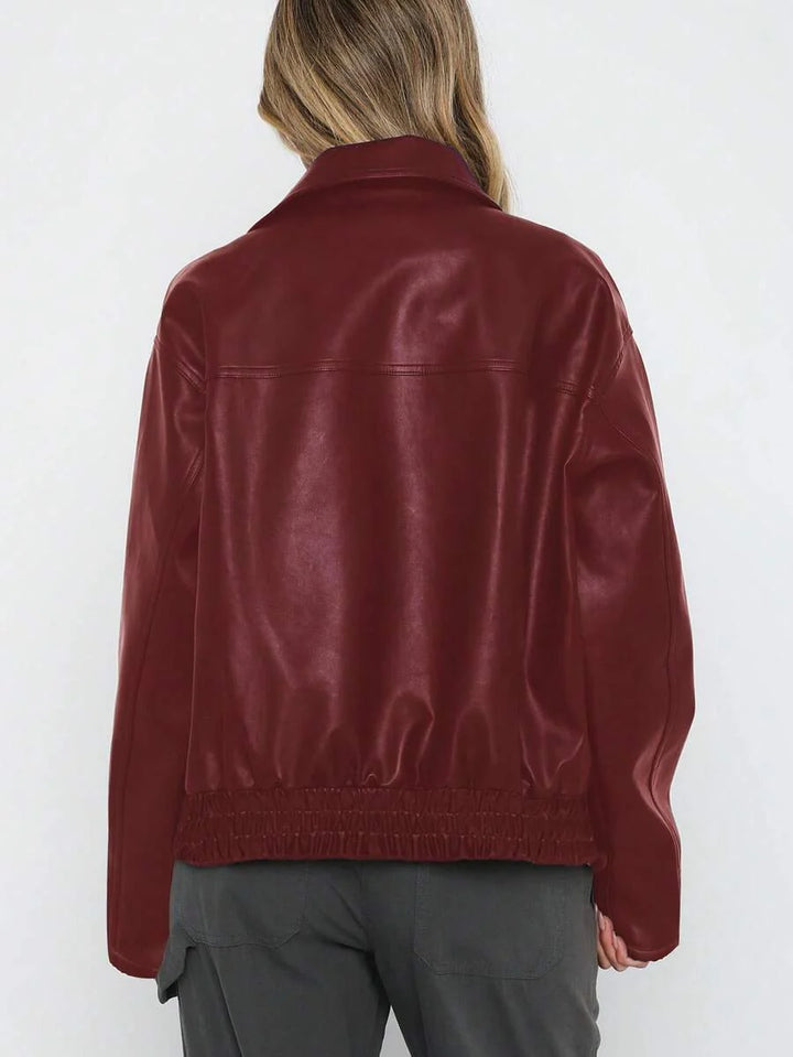 Woman wearing an oversized faux leather jacket with a wide collar and gathered hem