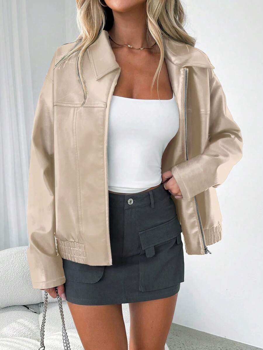 Woman wearing an oversized faux leather jacket with a wide collar and gathered hem