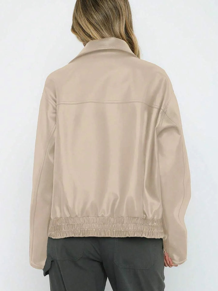 Woman wearing an oversized faux leather jacket with a wide collar and gathered hem
