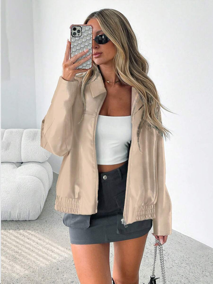 Woman wearing an oversized faux leather jacket with a wide collar and gathered hem