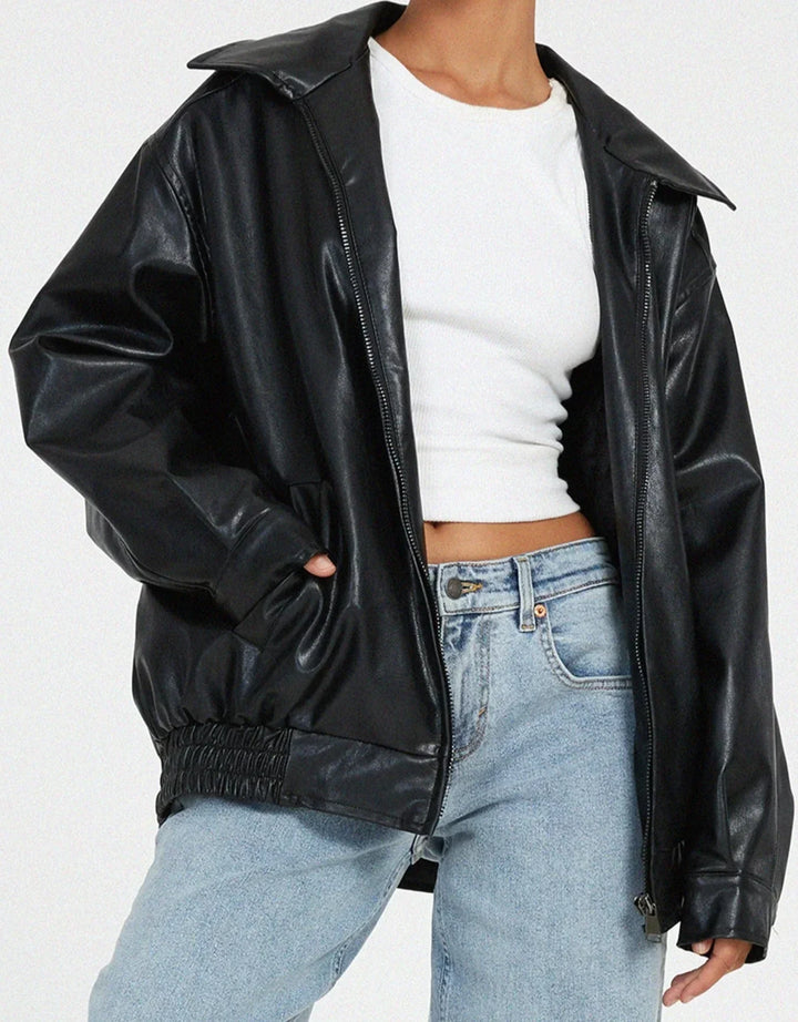 Woman wearing a boxy oversized faux leather jacket with a point collar