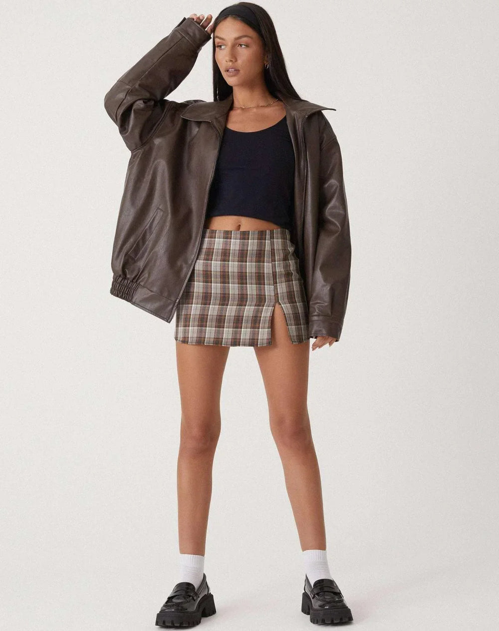 Woman wearing a boxy oversized faux leather jacket with a point collar