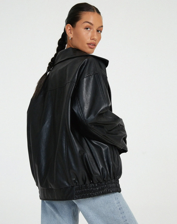 Woman wearing a boxy oversized faux leather jacket with a point collar
