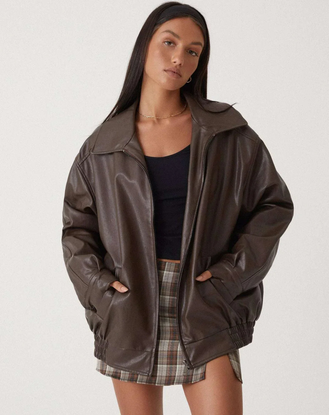 Woman wearing a boxy oversized faux leather jacket with a point collar