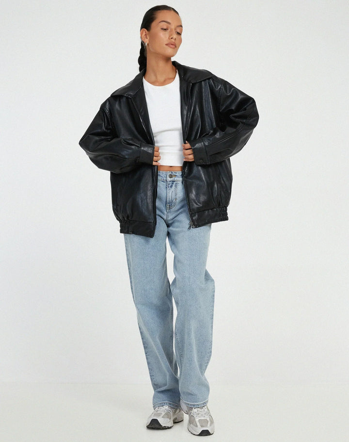 Woman wearing a boxy oversized faux leather jacket with a point collar