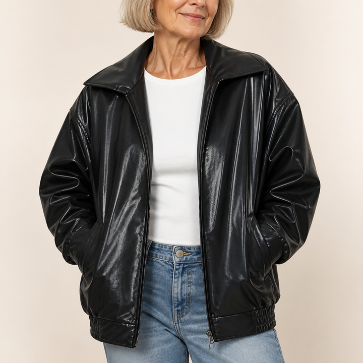 Woman wearing an oversized black faux leather bomber jacket with a point collar